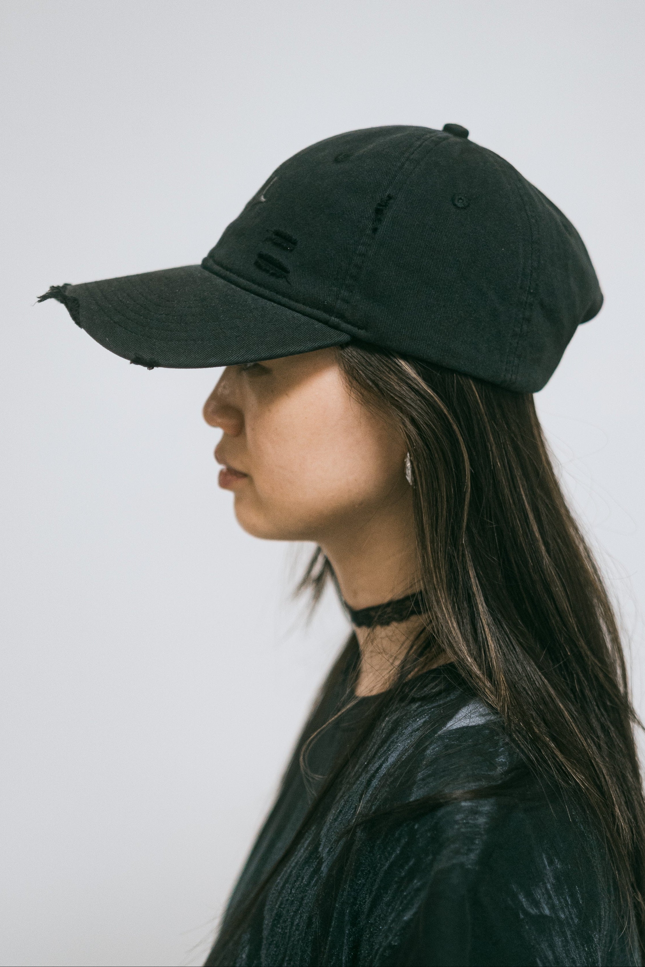 Casquette Drift en coton anthracite délavé, portée, vue de profil sur fond clair